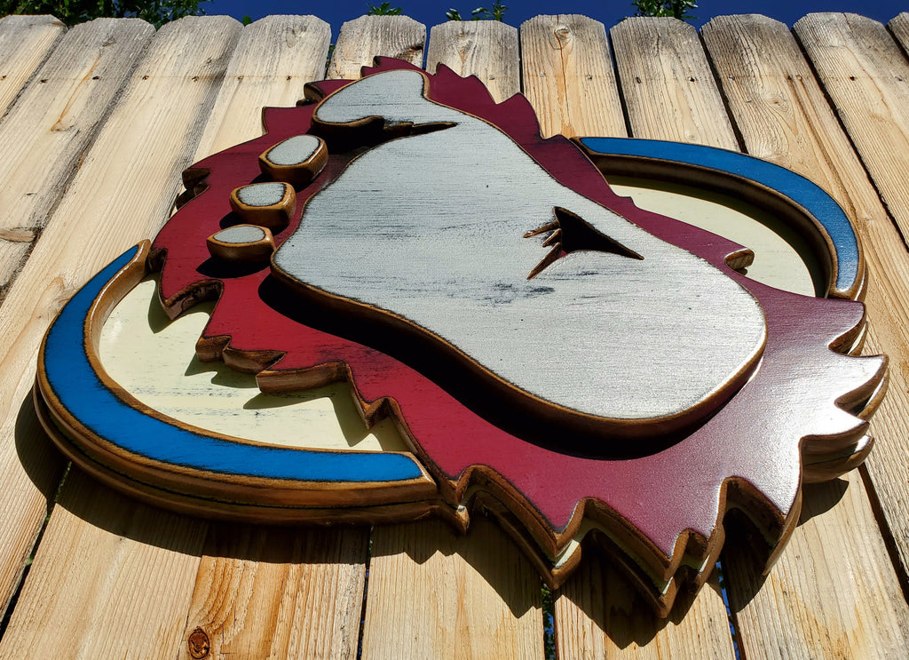 Wooden cutout of a bigfoot logo displayed on a wooden fence