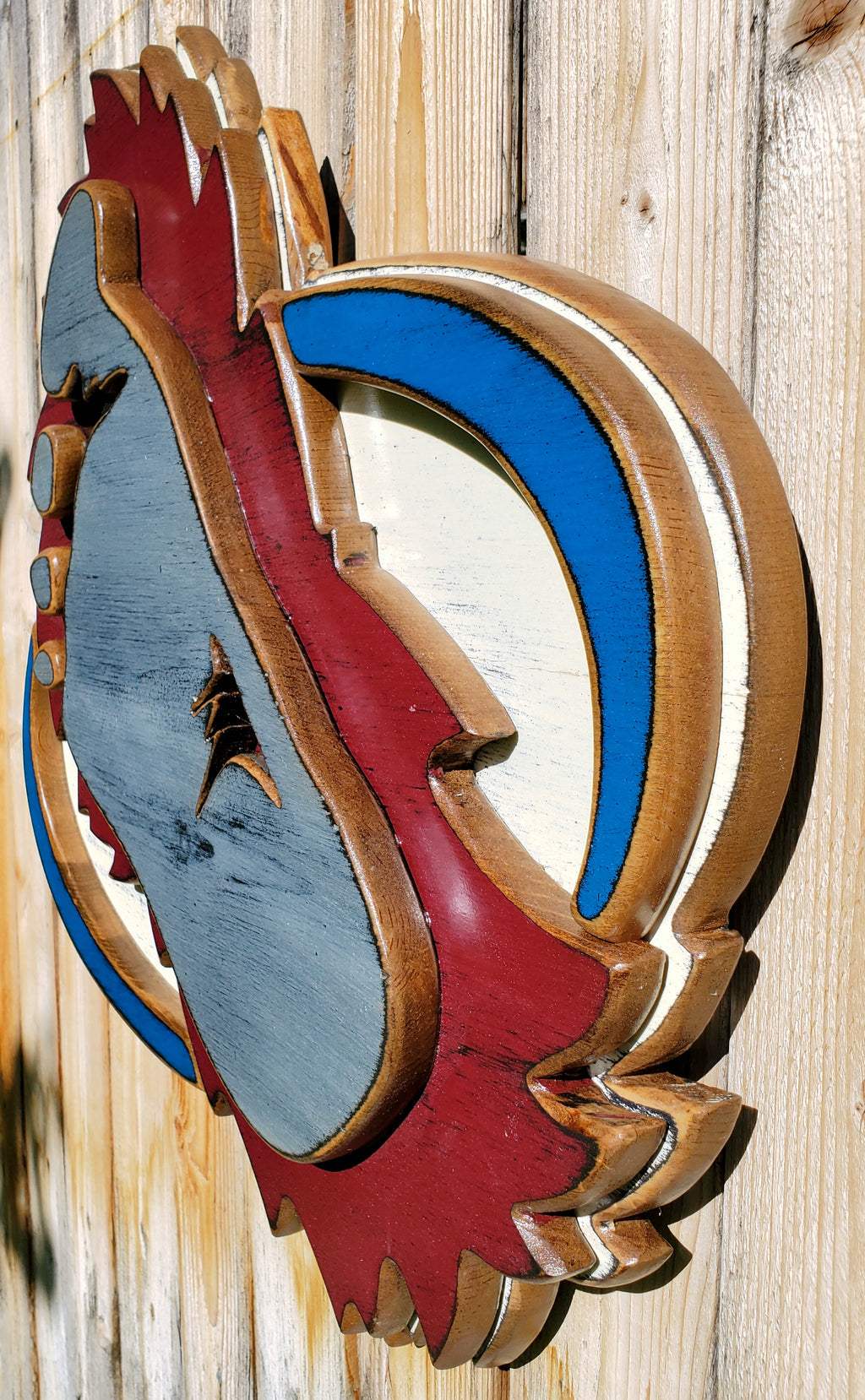 Wooden cutout of a bigfoot logo displayed on a wooden fence