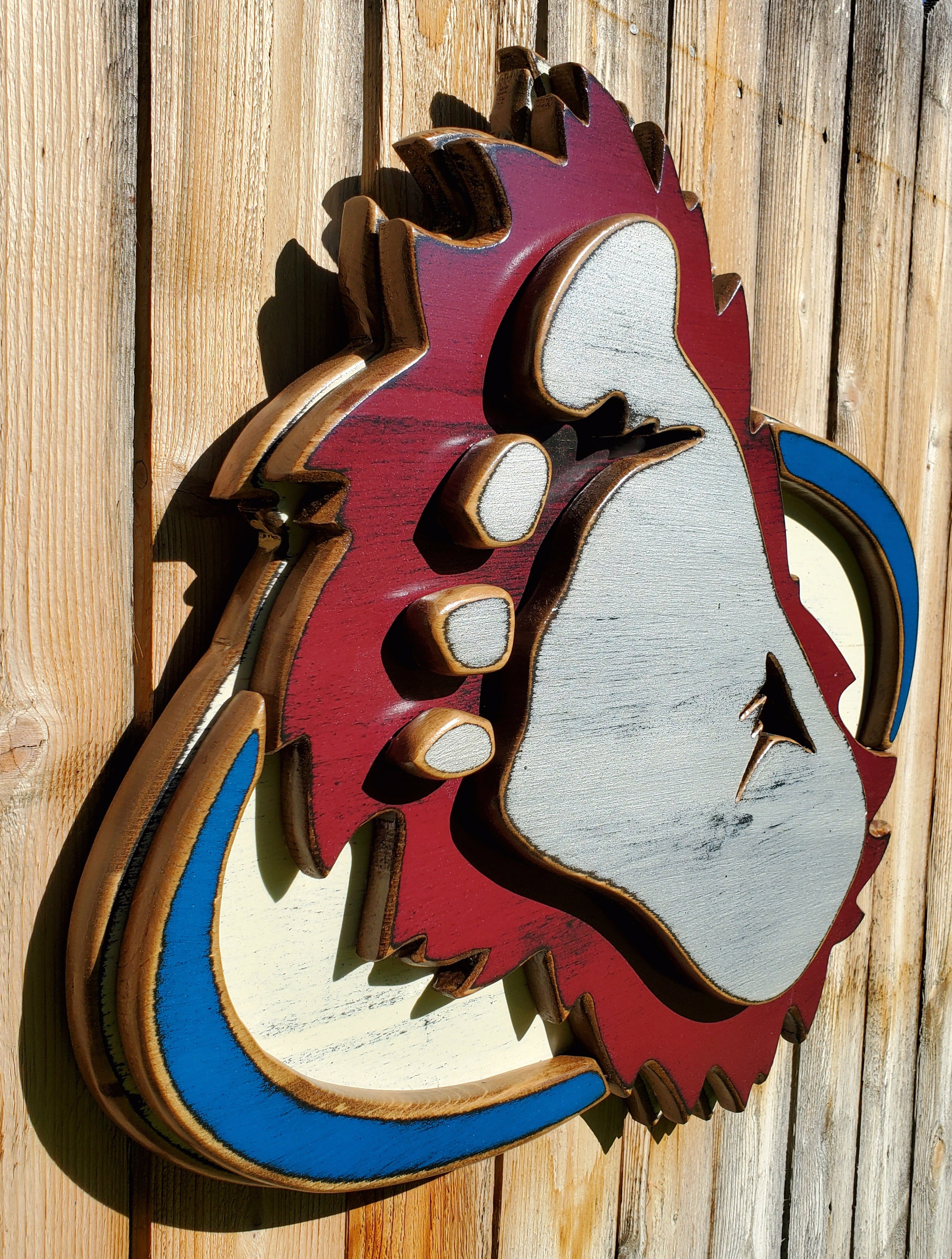 Wooden cutout of a bigfoot logo displayed on a wooden fence