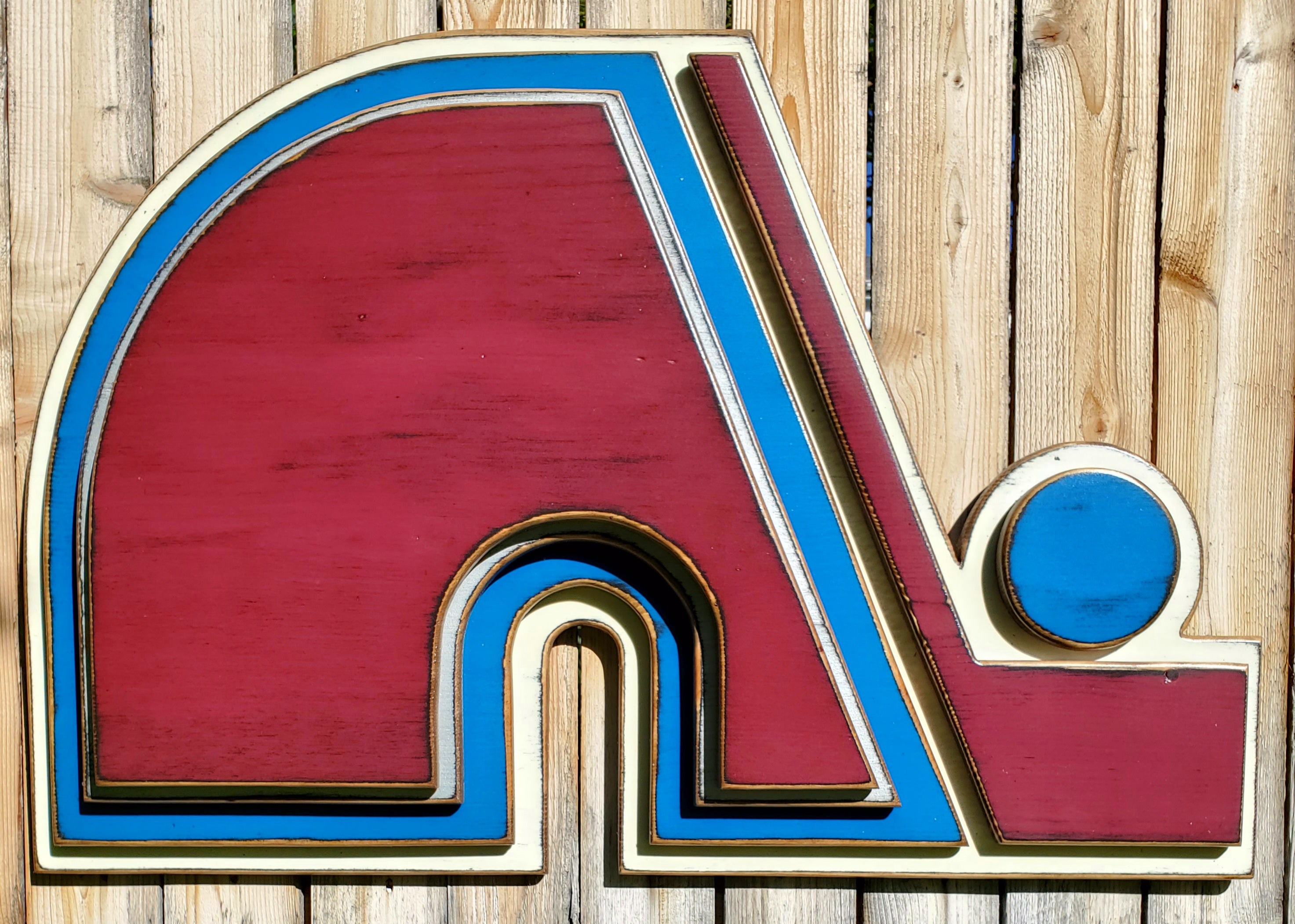 Wooden Nordique logo in 3D, painted in red, blue, and white