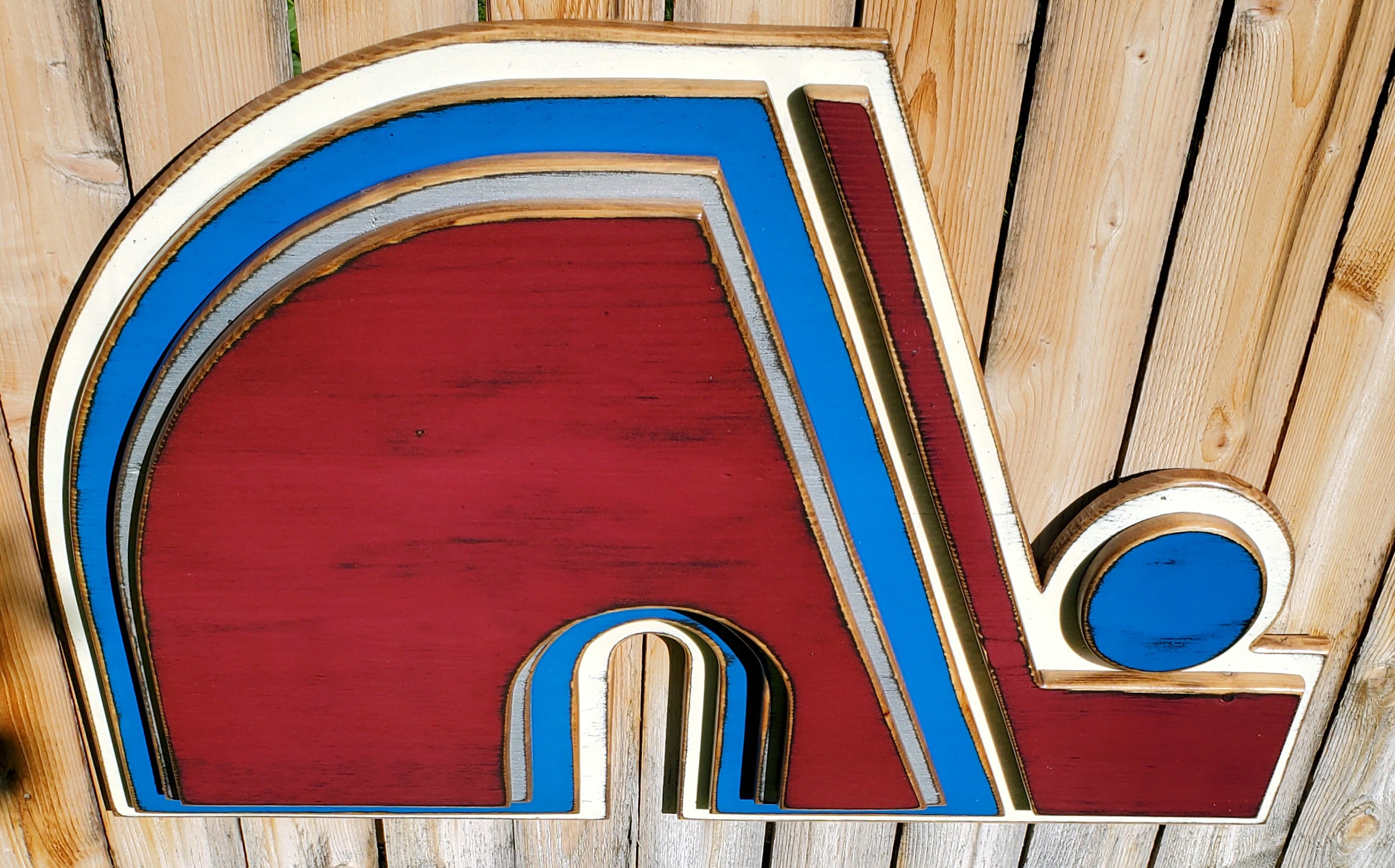 Wooden Nordique logo in 3D, painted in red, blue, and white