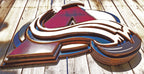 Colorful Avalanche A logo with abstract design hanging from a wooden fence