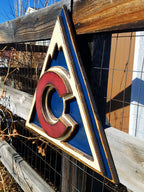 Colorful Avalanche triangle logo displayed on a metal lattice and wood fence