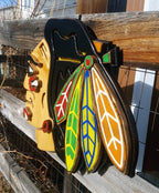Decorative wooden Native American with colorful feather design on a wooden fence