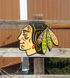 Decorative wooden Native American with colorful feather design on a wooden fence