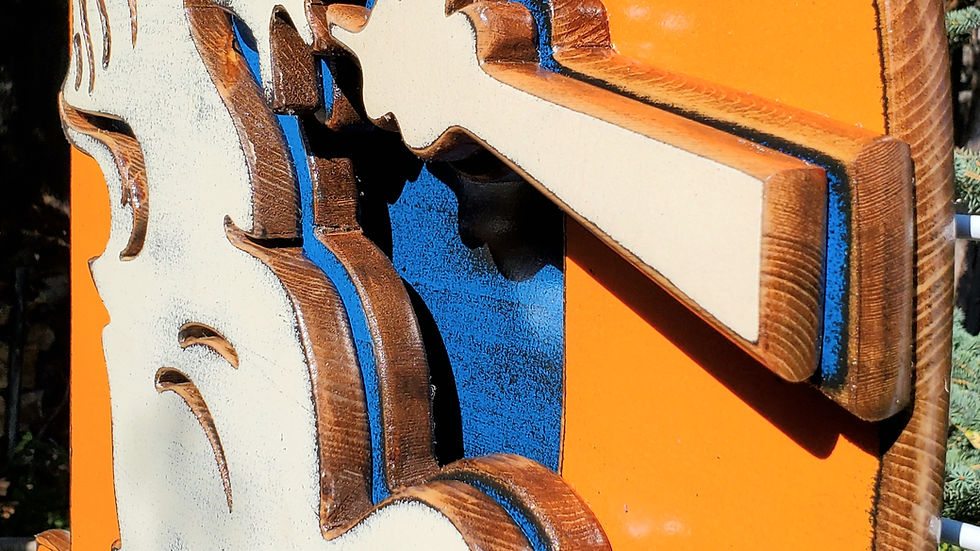 Wooden Broncos Retro "D" logo displayed on a metal lattice surround by trees and greenery in the background
