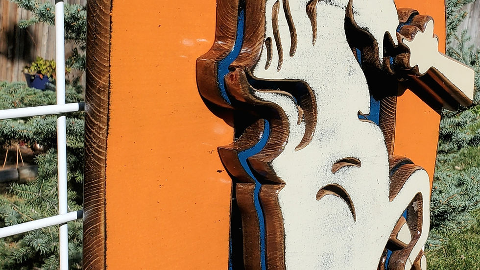 Wooden Broncos Retro "D" logo displayed on a metal lattice surround by trees and greenery in the background