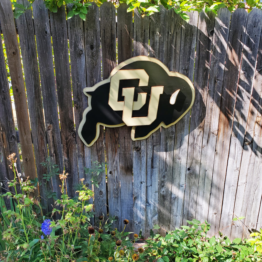 Wooden CU Buffs logo hanging on a wooden fence