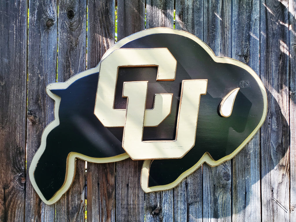 Wooden CU Buffs logo hanging on a wooden fence