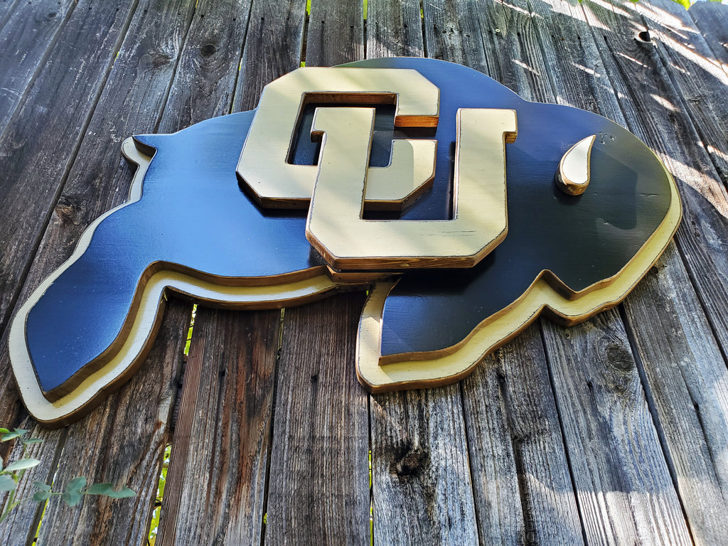 Wooden CU Buffs logo hanging on a wooden fence