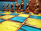 Chess set featuring cat figures on a colorful blue and yellow checkered board