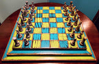 Colorful blue and yellow wooden chessboard with pieces on a round wooden table
