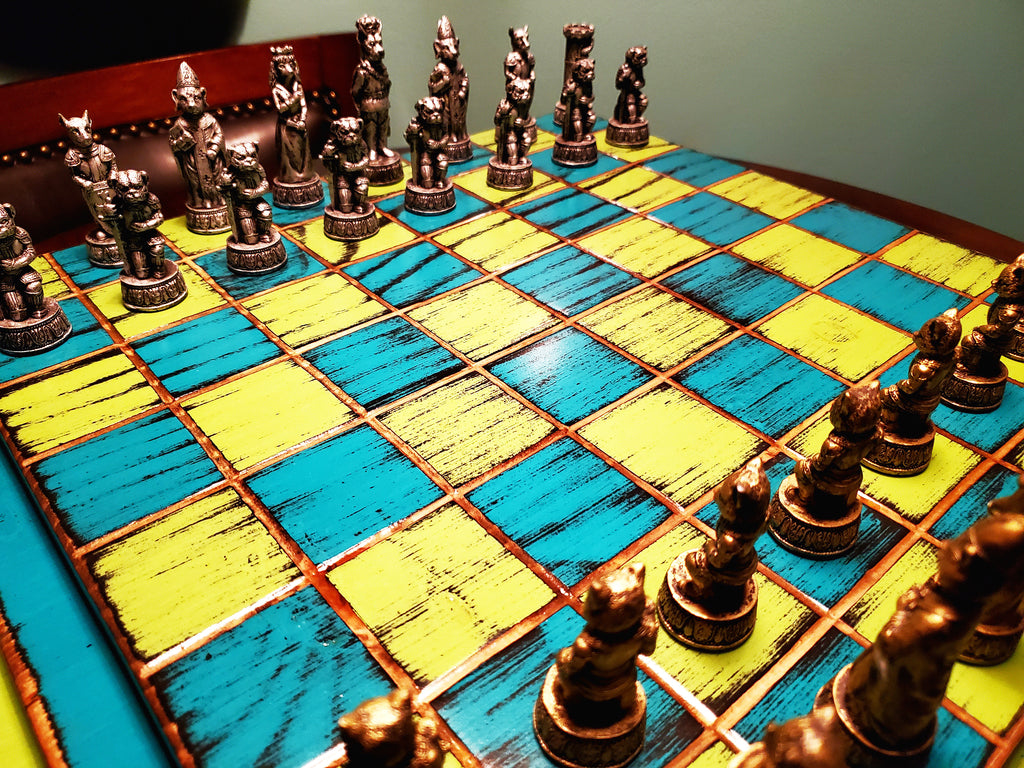 Chessboard with metallic chess pieces on a blue and yellow checkered surface