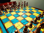 Chessboard with metallic chess pieces on a blue and yellow checkered surface