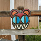 Decorative wooden wall art featuring Radiohead's Modified Bear logo on a wooden fence outdoors.