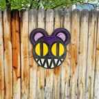 Decorative wooden wall art featuring Radiohead's Modified Bear logo on a wooden fence outdoors.
