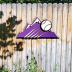 Decorative sign with Colorado Rockies purple mountain design and baseball on a wooden fence background