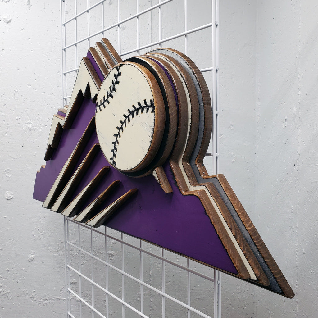 Decorative sign with Colorado Rockies purple mountain design and baseball on a metal grid background