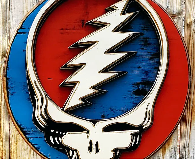 Grateful Dead Steal Your Face logo in red, white, and blue on a wooden background